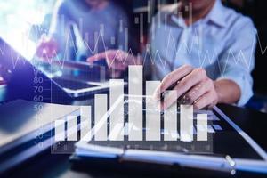 Business documents on office table with smart phone and calculator digital tablet and graph business with social network diagram and two colleagues discussing data working photo