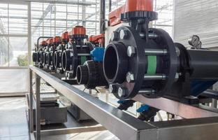 closeup of in a row of plastic pipes and water pumps photo