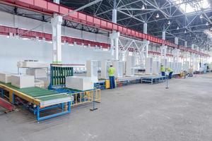 factory floor for production and assembly of household refrigerators on the conveyor belt. factory workers collect refrigerators on the conveyor belt photo