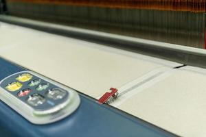 weaving loom at a textile factory, closeup. industrial fabric production line photo