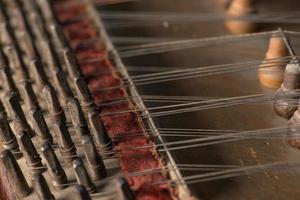 ancient Asian stringed musical instrument on black background with backlight. the similarity of the harp and psaltery. closeup photo