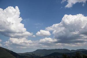 cielo azul brillante y gruesa capa de nubes blancas y esponjosas flotando sobre la montaña verde en bulgaria. foto