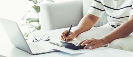 Woman is calculating annual tax with calculator and filling form of Individual Income Tax Return. Season to pay Tax and Budget planning concept. photo