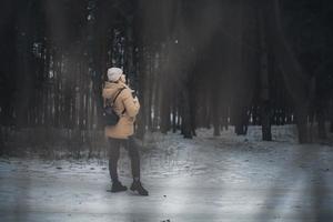 una joven de pelo rubio camina por el bosque. foto