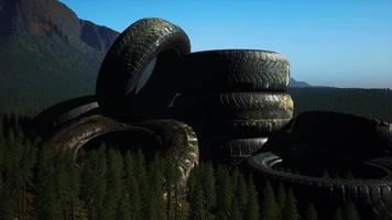 concept of environmental pollution with big old tires in mountain forest video