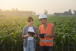 el ingeniero masculino brinda una consulta e instrucción a un agricultor inteligente con fertilizantes y pesticidas rociados con drones sobre tierras de cultivo, innovaciones de alta tecnología y agricultura inteligente foto