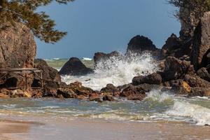 Waves and strong sea winds swept the rocks and shoals. Waves and sea breezes crash against rocks and shores. photo