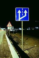 Road sign at night. Night scene with a traic signpost. photo