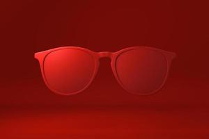 Red Glasses floating in red background. minimal concept idea creative. monochrome. 3D render. photo