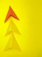 flecha de papel, concepto de liderazgo y éxito. concepto de negocio. sobre un fondo amarillo. nueva idea, coraje, nuevo pensamiento, solución creativa foto