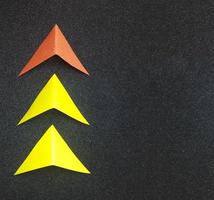 Paper arrow, concept of leadership and success. business concept. on a black background. new idea, courage, new thinking, creative solution photo
