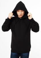 man in a black sweatshirt with a hood on his head is isolated on a white background photo