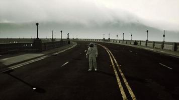 astronaut walks in the middle of a road photo