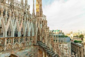 Roof of Milan Cathedral Duomo di Milano with Gothic spires and white marble statues. Top tourist attraction on piazza in Milan, Lombardia, Italy. Wide angle view of old Gothic architecture and art. photo