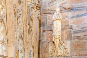 Roof of Milan Cathedral Duomo di Milano with Gothic spires and white marble statues. Top tourist attraction on piazza in Milan, Lombardia, Italy. Wide angle view of old Gothic architecture and art. photo