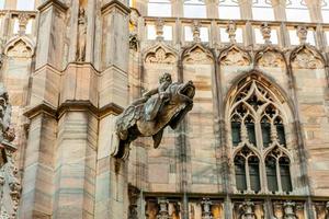 Roof of Milan Cathedral Duomo di Milano with Gothic spires and white marble statues. Top tourist attraction on piazza in Milan, Lombardia, Italy. Wide angle view of old Gothic architecture and art. photo