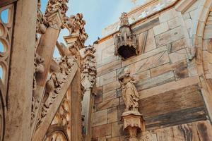 Roof of Milan Cathedral Duomo di Milano with Gothic spires and white marble statues. Top tourist attraction on piazza in Milan, Lombardia, Italy. Wide angle view of old Gothic architecture and art. photo