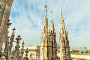 Roof of Milan Cathedral Duomo di Milano with Gothic spires and white marble statues. Top tourist attraction on piazza in Milan, Lombardia, Italy. Wide angle view of old Gothic architecture and art. photo