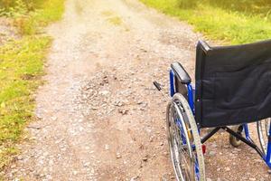 silla de ruedas vacía parada en la carretera esperando servicios para pacientes. silla de ruedas para personas con discapacidad estacionada al aire libre. accesible para persona con discapacidad. concepto médico de atención médica. foto