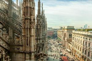 Roof of Milan Cathedral Duomo di Milano with Gothic spires and white marble statues. Top tourist attraction on piazza in Milan, Lombardia, Italy. Wide angle view of old Gothic architecture and art. photo