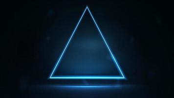 Neon triangular frame on dark background. Blue digital hologram neon triangle border with copy space in dark room.