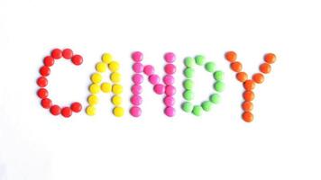 Candy palabra de coloridos caramelos recubiertos de chocolate aislado sobre fondos blancos arriba foto