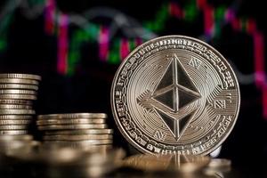 Golden Ethereum ETH coin and defocused chart background. Virtual cryptocurrency concept. photo