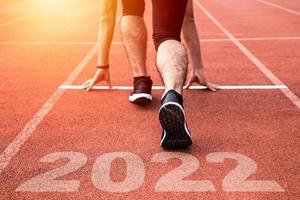 Sporty Man waiting at the Starting line to Start the New Year 2022 with sunset light. New Goals, Plans and Visions. photo