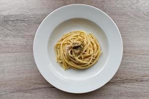 Italian Spaghetti Pasta with Tuna, Spaghetti al tonno, on wooden background. Top view. photo