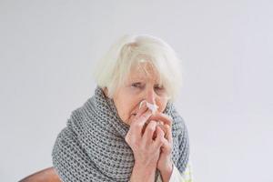 senior ill woman in scarf freezing cold at home. Health care, crisis, oldness concept photo
