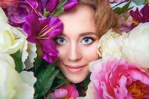 hermoso retrato de niña en flores de colores de primavera foto