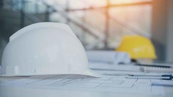 Yellow helmet on the table with blueprints. Safety project of workman as engineer or worker on concrete floor. photo