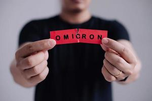 Man with a stethoscope Tear the red paper with the word Omicron. New generation vaccine against Coronavirus South African variant. Omicron variant of SARS-CoV-2. New B.1.1.529 Variant of concern photo