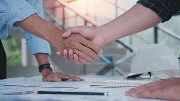 Two engineering man with construction worker greeting a foreman at renovating apartment. Engineering objects on workplace with partners interacting on background photo