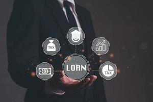 Close up of businessman hand holding LOAN icons over the Network connection. Non performing loans. Businessman pressing a Business Loan concept button. photo