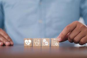 Man hand arranging wood block stacking with the healthcare medical icon. Health insurance - health concept photo