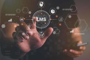 Man hand touching virtual screen to  LMS - Learning Management System web icon for lesson and online education, course, application, study, e learning, knowledge everywhere and every time. photo