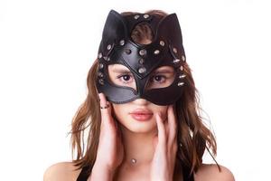 Leather, elegant, black mask of the cat on young female model on white background. isolate. close-up, portrait photo