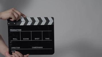 filmskiffer eller clapperboard slå. närbild hand som håller tom filmskiffer och klappar den. video