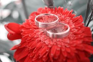 A pair of wedding rings on a bouquet of flowers photo