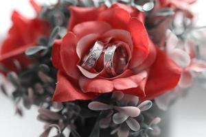 A pair of wedding rings on a bouquet of flowers photo
