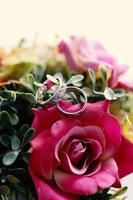 A pair of wedding rings on a bouquet of flowers photo