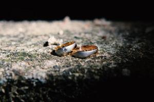 un par de anillos de boda en una roca foto