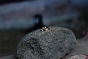 A pair of wedding rings on a rock. Wedding rings symbol love family. photo