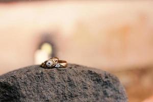 A pair of wedding rings on a rock. Wedding rings symbol love family. photo