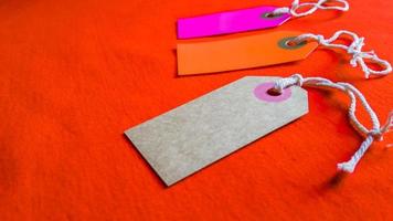 three colored tags on a white rope, red background photo