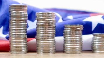 American coins with the flag of the United States of America. Investment concept, business finance and money saving. US coins stacked against the background of the American flag. Selective focus. photo