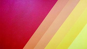 The wall is painted in red, pink, orange, yellow color with diagonal lines. Colorful background for your text and message with copy space. photo