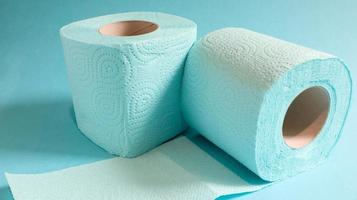 Blue roll of modern toilet paper on a blue background. A paper product on a cardboard sleeve, used for sanitary purposes from cellulose with cutouts for easy tearing. Embossed drawing photo