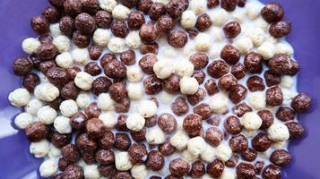 Healthy breakfast with milk on the table in a deep plate. Whole grain chocolate and milk balls. Healthy cereal breakfast. Children's breakfast. Baby food. Balanced diet. Dry ready and quick snack photo